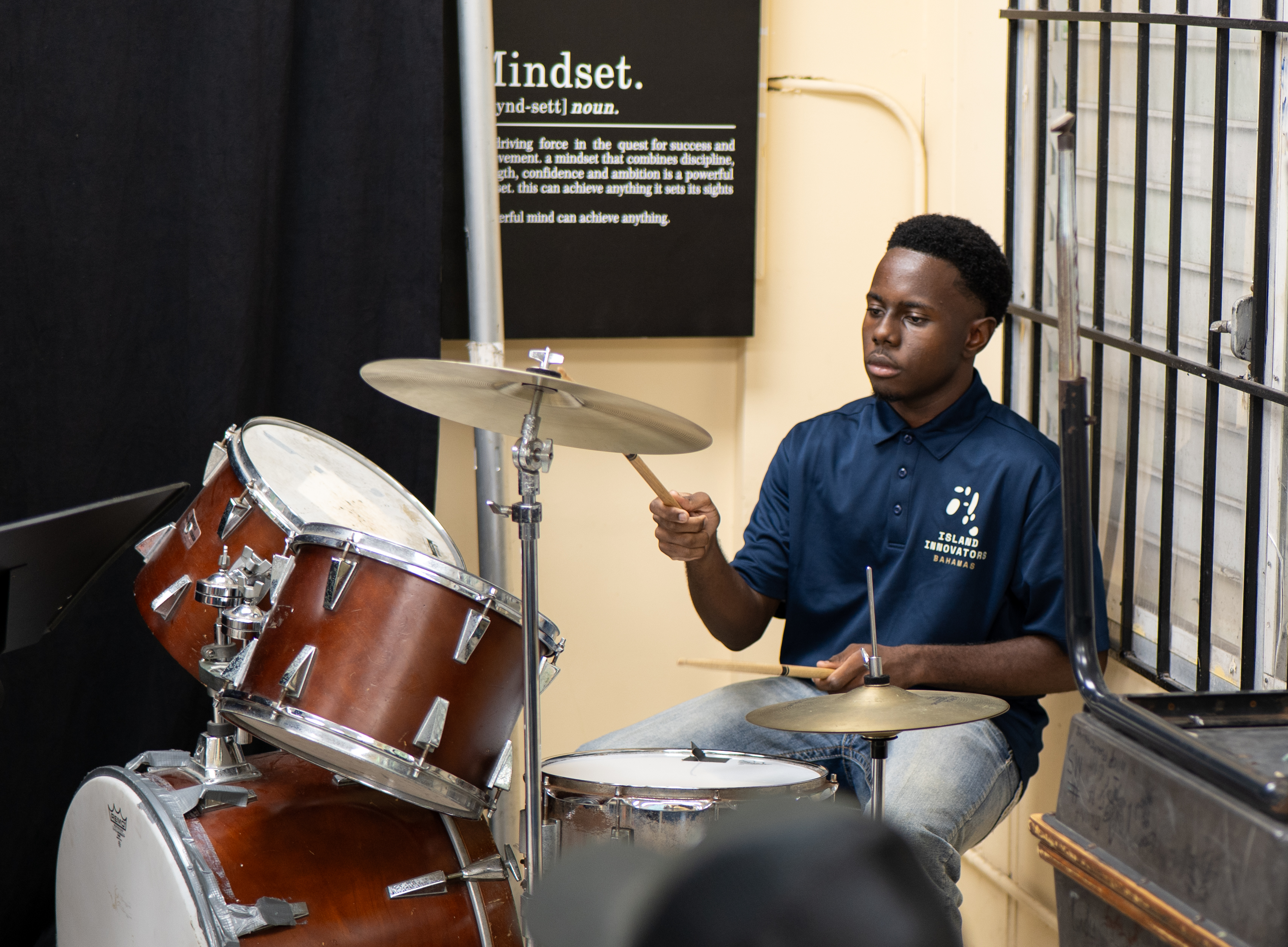 Island Innovators Bahamas 2026 student playing drums during the public showcase